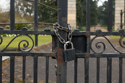 A Lock and Chain on Metal Fence Gate to the Road