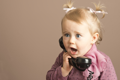 Baby girl in surprise talking on a vintage phone
